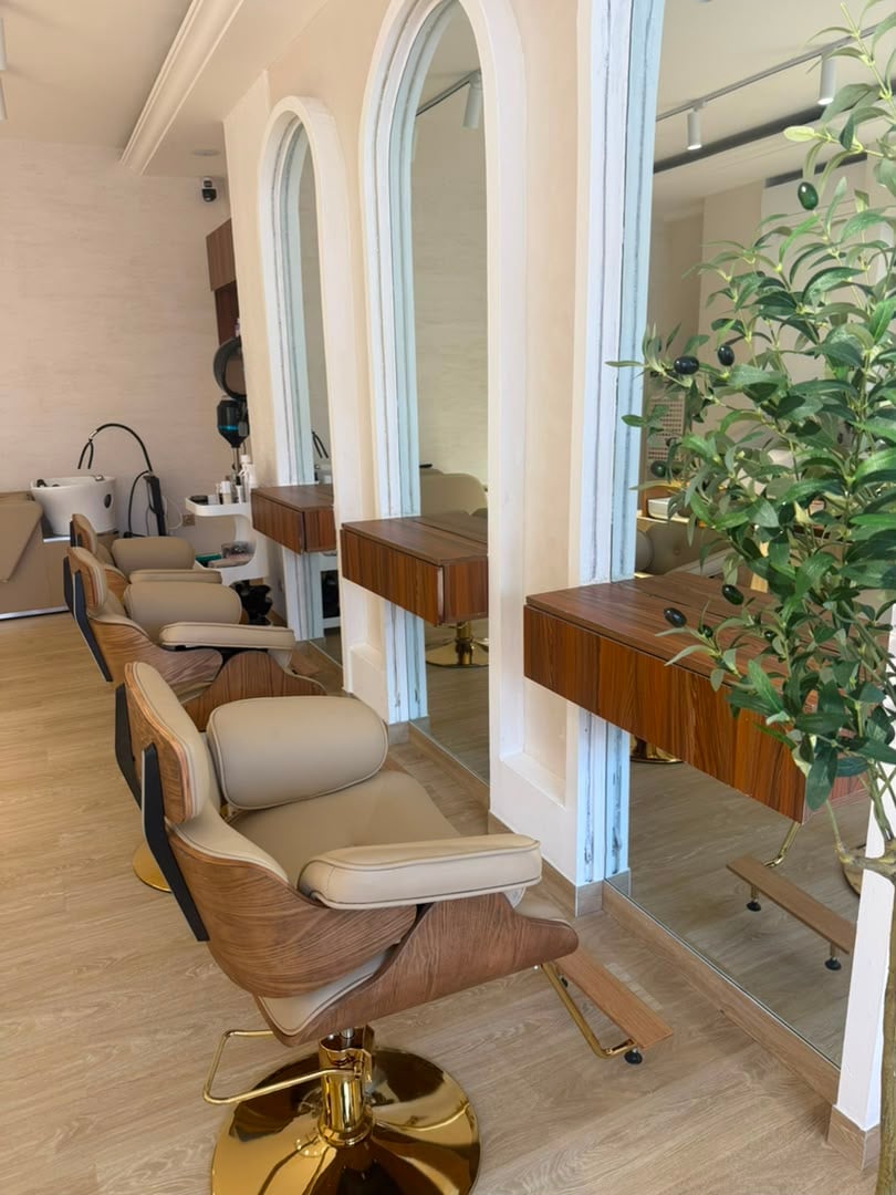 Coin coiffure — fauteuils crème et bois clair